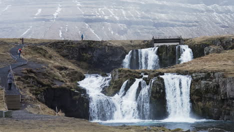 Large-view-of-the-waterfall-with-tourists,-Kirkjufell,-Iceland