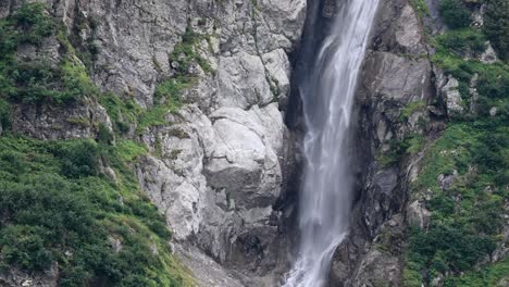 Waterfall-crashes-in-valley-of-alpine-rocky-mountain,-Switzerland,-Engelberg,-Obwalden