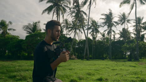 Medium-shot-of-content-creator-filming-with-big-camera-in-tropical-location