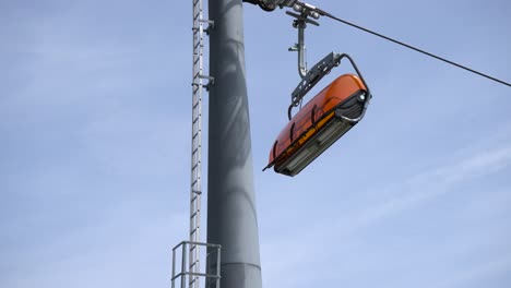 Camera-tracking-and-following-an-empty-chairlift-from-below-in-mountain-range