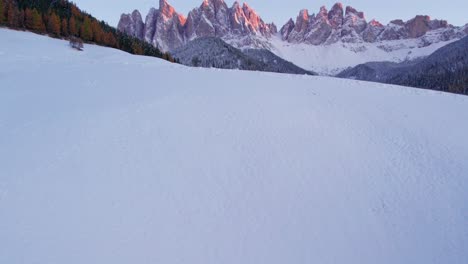 Winter-snow-covered-field-in-peaceful-Alpine-valley-during-sunset,-Dolomites