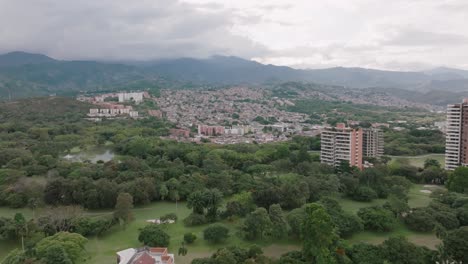 Fast-aerial-flyover-of-apartment-buildings-and-neighborhoods-with-mountains-in-the-background-in-Cali,-Colombia