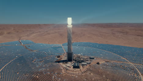Solar-power-tower-focused-sunlight-for-movable-mirrors-at-the-desert-sun-non-time-in-a-cloudless-day--slow-tracking-paralax-drone-shot
