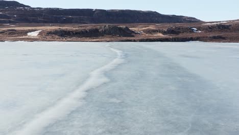 Ice-sheet-on-Urriðavatn-lake-in-east-Iceland,-aerial