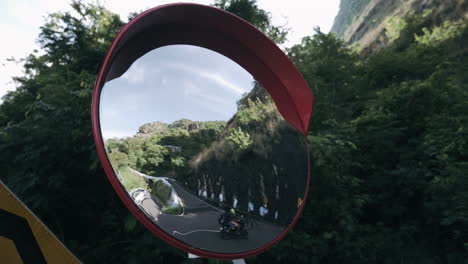 Round-traffic-convex-mirror-mounted-on-a-hairpin-bend-of-a-mountain-road