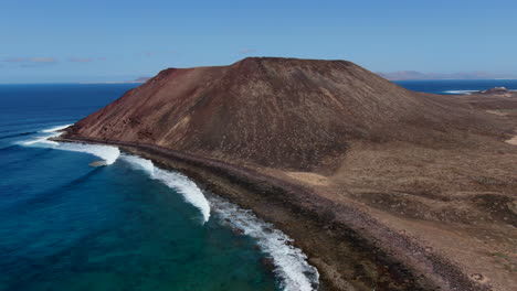 Fantastic-orbit-aerial-shot-on-a-sunny-day-of-the-volcano-of-the-island-of-wolves,-in-the-canary-islands