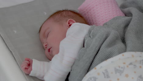 Slow-parallax-looking-down-on-baby-girl-sleeping-peacefully-on-her-side