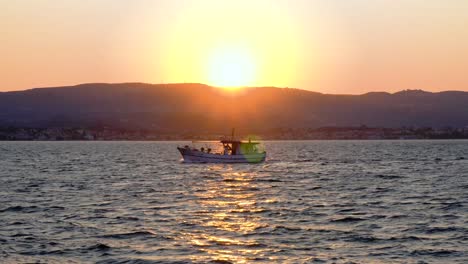 4k-24fps-Handgeführte-Hintergrundbeleuchtete-Aufnahme-Eines-Fischerbootes,-Das-Im-Morgengrauen-Vor-Der-Sonne-Kreuzt