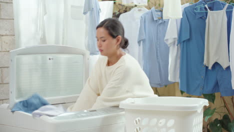 Junge-Domestizierte-Frau-Legt-Wäsche-Aus-Dem-Korb-In-Die-Waschmaschine
