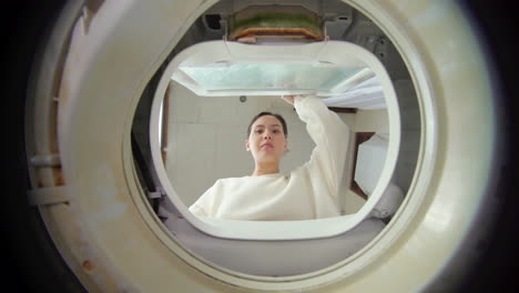 Woman-Opens-The-Lid-And-Looking-Inside-The-Washing-Machine