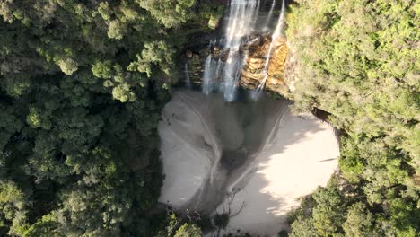 Bird-flying-over-a-waterfall-seen-from-a-drone