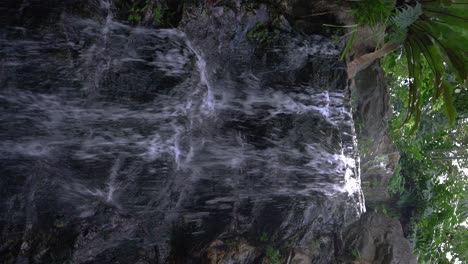Vertical-video---Close-up-locked-off-shot-of-small-waterfall
