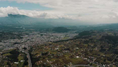Panoramic-View-Over-City-Of-Otavalo,-Ecuador-Near-San-Pablo-Lake-And-Imbabura-Volcano---drone-shot