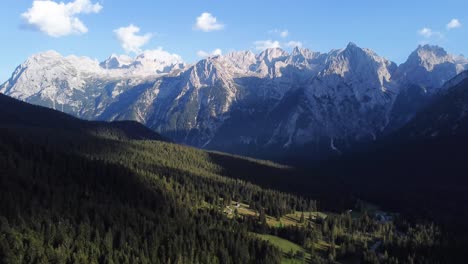 Rotational-4K-drone-shot-of-a-stunning-valley-full-of-pine-trees-with-unique-and-outstanding-mountain-and-rock-formations-in-the-background-in-the-beautiful-area-of-the-Dolomites-in-North-Italy