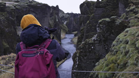 Tourist-taking-picture-in-Fjadrargljufur-canyon-in-Iceland