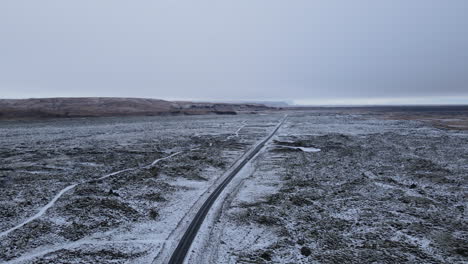 Toma-Aérea-De-Un-Camión-De-Remolque-Solo-En-Un-Largo-Camino-En-Medio-De-La-Nada-En-Islandia-Durante-El-Invierno