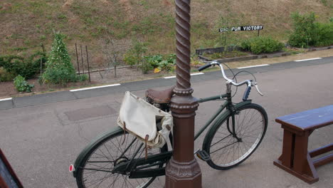 Ein-Altes-Fahrrad,-Das-Sich-Während-Des-Zweiten-Weltkriegs-Auf-Einen-Pfosten-An-Einem-Bahnhof-Stützte,-Mit-Einem-Britischen-Siegeszeichen