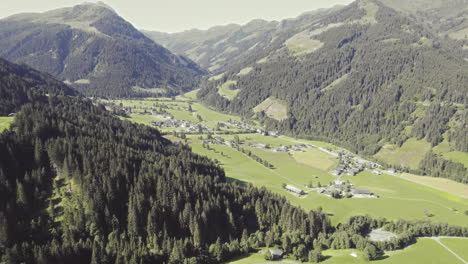 Aerial-over-picturesque-tyrolean-countryside-with-forest-covered-mountains-and-grassy-fields-1