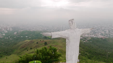 Slow-rotating-aerial-footage-of-the-Cristo-Rey-Jesus-statue-on-top-of-a-mountain-with-radio-towers-all-around-outside-of-Cali,-Colombia