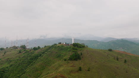 Super-fast-aerial-wide-to-close-footage-of-the-Cristo-Rey-Jesus-statue-on-top-of-a-mountain-outside-of-Cali,-Colombia