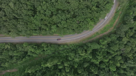 Top-down-aerial-zoom-out-footage-of-a-curvy-road-in-the-mountains-in-southern-Virigina