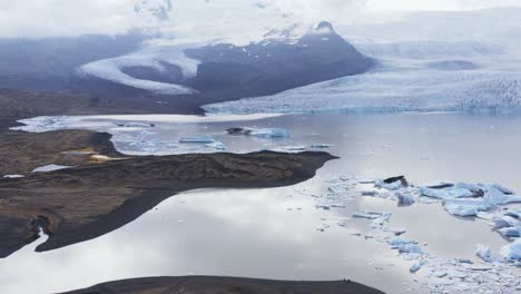 Gletscherlagune-Mit-Gekalbten-Eisbergen-Und-Entferntem,-Sich-Zurückziehendem-Gletscher,-Auswirkungen-Der-Globalen-Erwärmung-Auf-Die-Arktis,-Antenne