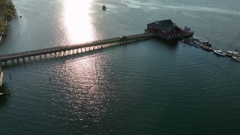 Orbiting-drone-shot-of-the-Coupeville-public-dock-with-a-truck-slowly-driving-away-after-delivering-goods-to-the-restaurant