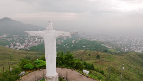 Aerial-footage-flying-past-the-right-side-of-the-Cristo-Rey-Jesus-statue-on-top-of-a-mountain-outside-of-Cali,-Colombia