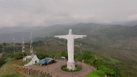 Aerial-zoom-out-reveal-of-the-Cristo-Rey-Jesus-statue-on-top-of-a-mountain-outside-of-Cali,-Colombia