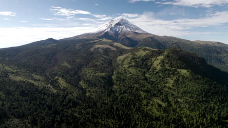 Backwards-drone-shot-with-panoramic-view-of-the-snowy-peak-of-popocatepetl-volcano-in-mexico-city