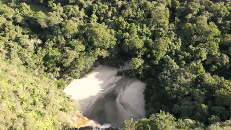 Waterfall-seen-from-above-with-a-bird-flying-over-the-forest