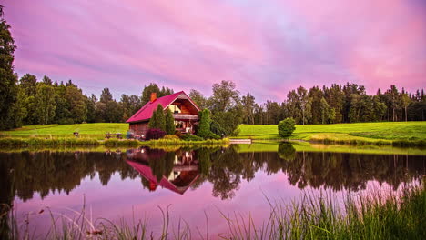 A-family-enjoys-an-outdoor-meal-by-a-cabin-during-a-colorful-sunset---time-lapse