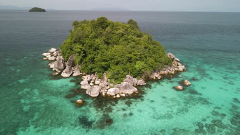 Aerial-arc-shot-circling-around-a-tiny-forested-island-near-Ko-Lipe,-Thailand