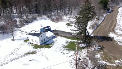 Luftaufnahmen-Von-Drohnen,-Die-Um-Ein-Altes,-Weißes-Haus-Am-Rande-Eines-Schneebedeckten-Waldes-Kreisen