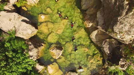 People-in-river,-green-nature-and-rocks