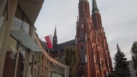 Polnische-Flagge,-Die-Vom-Wind-Vor-Einer-Kathedrale-In-Warschau-Geschwenkt-Wird