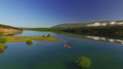 Gente-Haciendo-Kayak-En-El-Río,-Naturaleza-Verde-Y-Cielo-Azul