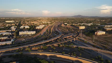 4K-Luftaufnahme-Des-Geschäftigen-Verkehrs-An-Einem-Autobahnkreuz-In-Arizona,-Straßenkreuzung-Der-Autobahnen-101-Und-202-Am-Späten-Abend