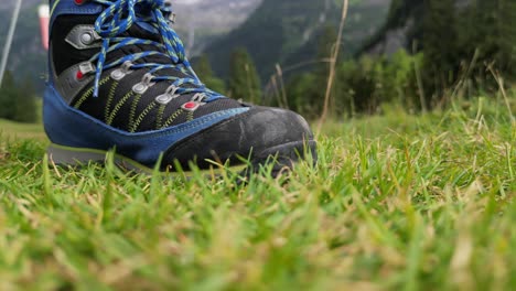 Shoe-of-a-hiker-on-the-ground-in-the-mountains-in-a-grass-field,-swiss-alps,-obwalden