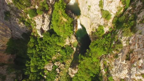 Menschen,-Die-Im-Fluss-In-Der-Nähe-Von-Wasserfall,-Grüner-Natur-Und-Felsen-Schwimmen