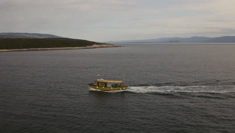 Barco-De-Pesca-Navegando,-Isla-En-Segundo-Plano