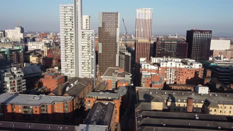 Aerial-drone-flight-in-Manchester-City-Centre-showing-Newly-constructed-towers-and-rooftops-with-the-Kimpton-Hotel-on-Oxford-Road