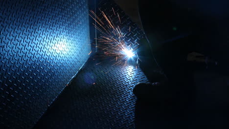 Blinding-welding-arc-smoldering-metal-sheet-so-that-it's-connected