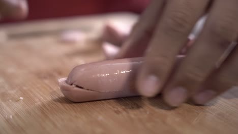Guy-cutting-sausage-on-a-wooden-board