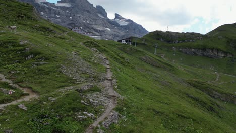 Natural-mountain-gravel-path-to-walk-in-the-mountains,-swiss-alps-in-Obwalden,-drone-aerial-view