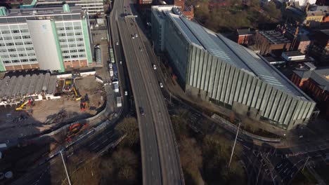 Aerial-Drone-Flight-over-the-Mancunian-Way-showing-the-cars-and-rooftops-below-in-Manchester-City-Centre-UK