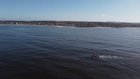 Aerial-tracking-shot-of-Fishing-boat-on-uruguayan-coast-in-the-atlantic-ocean-in-summer