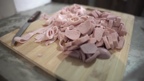 Chopped-sausage-and-ham-on-a-wooden-board