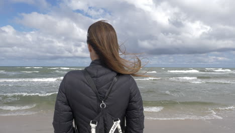 Cinematic-shot-of-woman-admiring-the-ocean-and-the-waves-1
