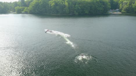 A-person-is-pushed-behind-a-boat-while-participating-in-the-surface-water-sport-of-water-skiing,-also-known-as-waterskiing-or-water-skiing